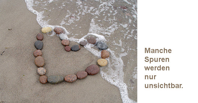 Steine-Herz am Strand mit Text: Manche Spuren werden nur unsichtbar.